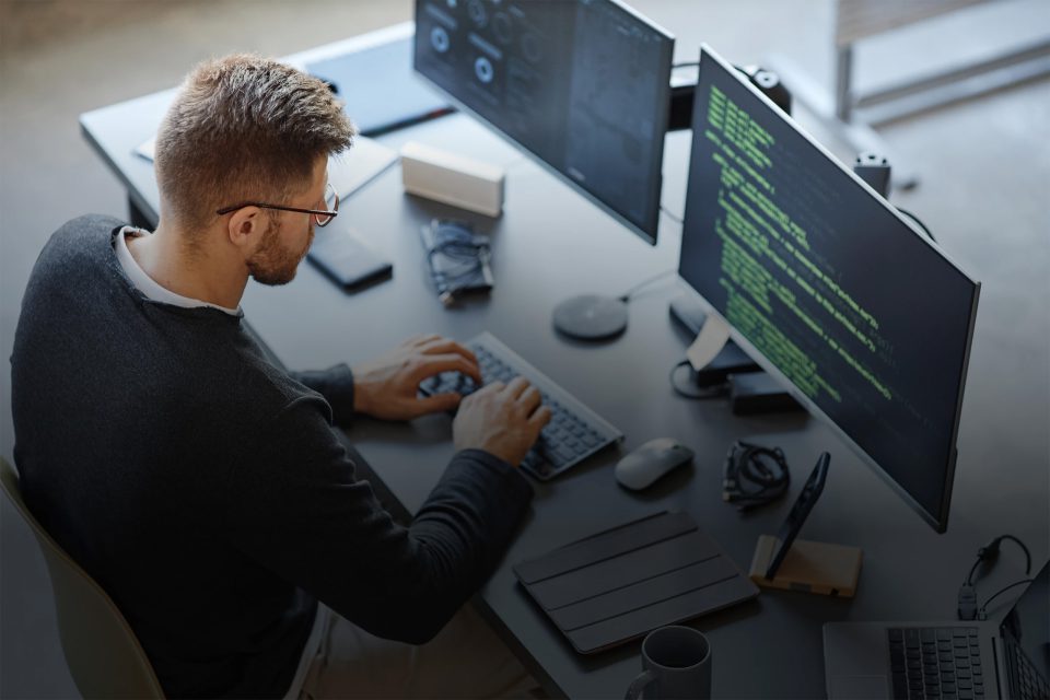 Specialist aan het werk achter twee beeldschermen